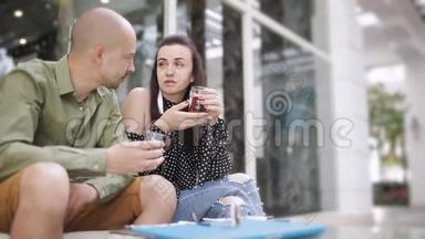 男人和女人在街头咖啡馆<strong>喝茶</strong>，看智能手机上的<strong>照片</strong>